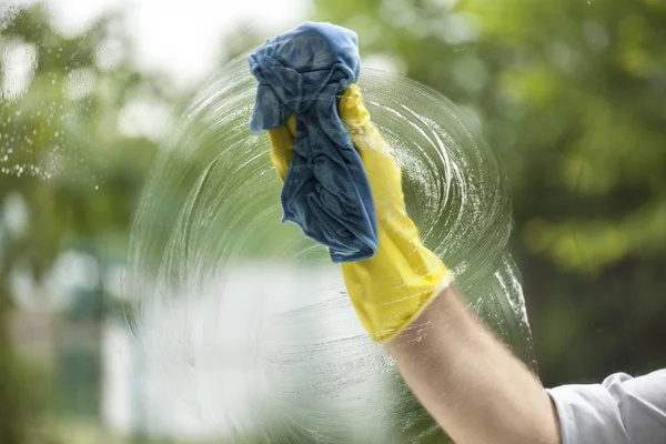 Gloved hand cleaning window — Stock Photo, Image