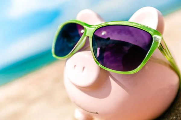 Banco Piggy com óculos de sol na praia — Fotografia de Stock