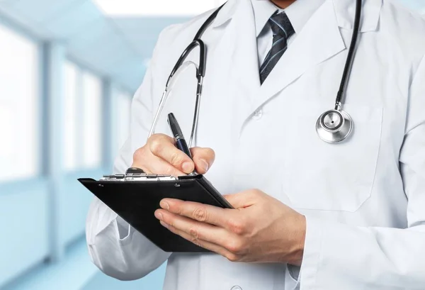 Doctor with stethoscope writing — Stock Photo, Image