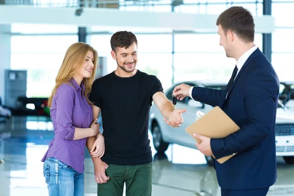 Feliz pareja con concesionario de coches — Foto de Stock