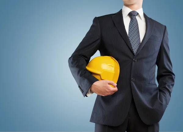 Businessman  holding in hand yellow helmet — Stock Photo, Image