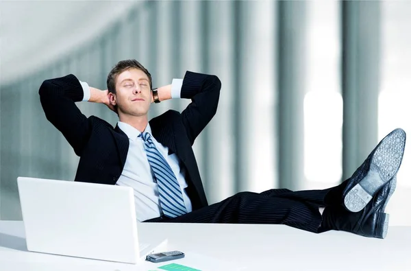 Geschäftsmann entspannt sich in der Nähe von Laptop — Stockfoto