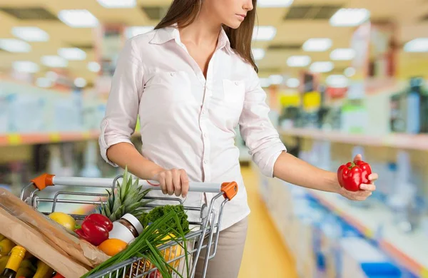 Jonge vrouw winkelen in de supermarkt — Stockfoto