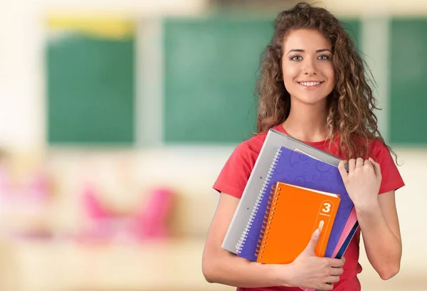 Estudante menina segurando cadernos coloridos — Fotografia de Stock