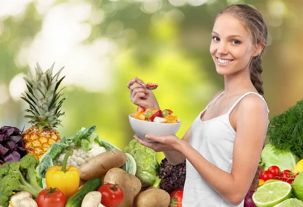 Mujer joven con tazón de ensalada de frutas — Foto de Stock