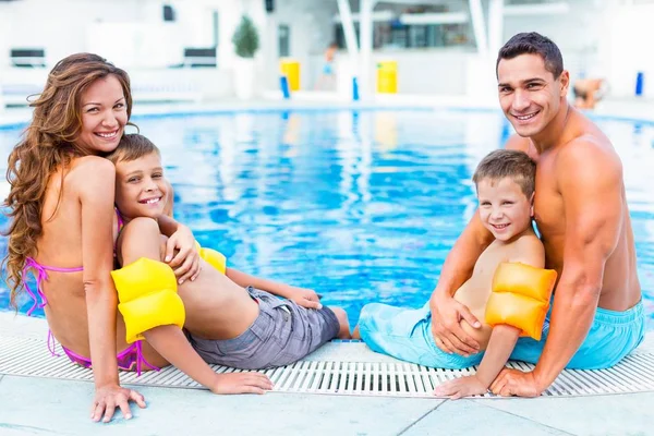 Família feliz brincando na piscina. — Fotografia de Stock