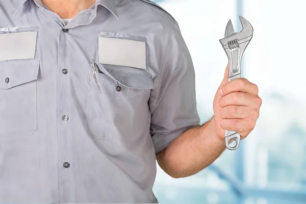 Man in work uniform holding tool — Stock Photo, Image