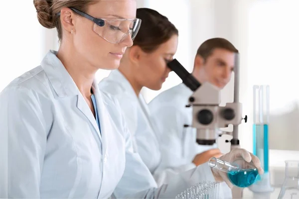 Cientistas que trabalham com microscópio — Fotografia de Stock