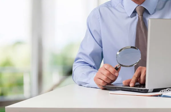 Business man holding magnifying glass — Stock Photo, Image