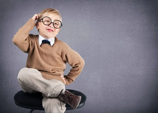 Young boy in  glasses thinking Stock Picture