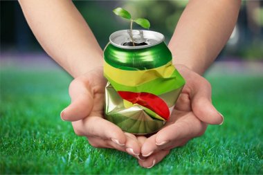hands holding metal can with plant clipart