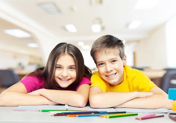 Children sitting by the table during lesson — Stock Photo, Image