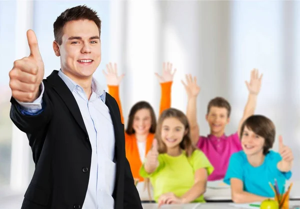 Young teacher showing thumb up — Stock Photo, Image