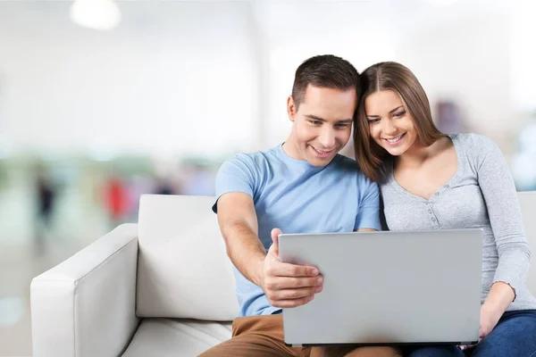 Lachende paar met de laptop op de Bank — Stockfoto