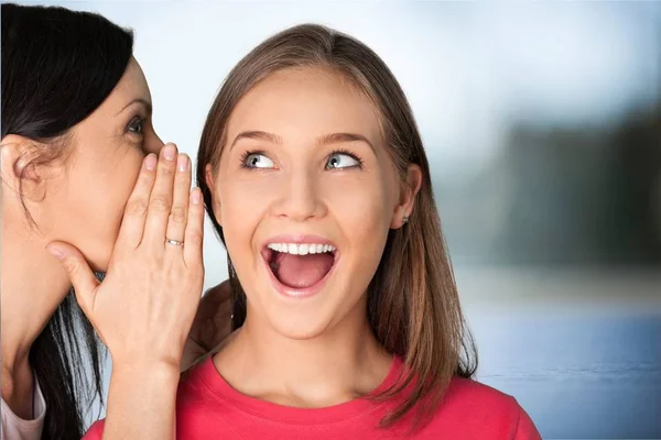 Mujeres sonrientes susurra — Foto de Stock