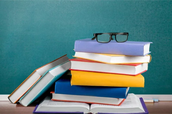 Книги и очки на фоне стола — стоковое фото