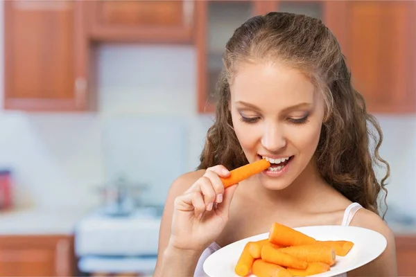 Mujer joven comiendo una zanahoria —  Fotos de Stock