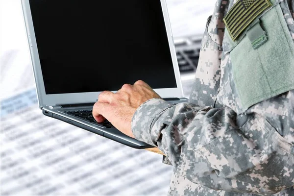 dizüstü bilgisayar ile askeri adam elinde