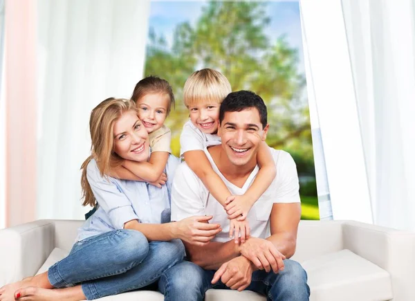 smiling family sitting at sofa