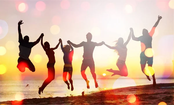 Amigos pulando na praia — Fotografia de Stock