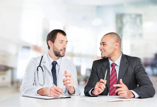 Médico sonriendo con paciente masculino — Foto de Stock