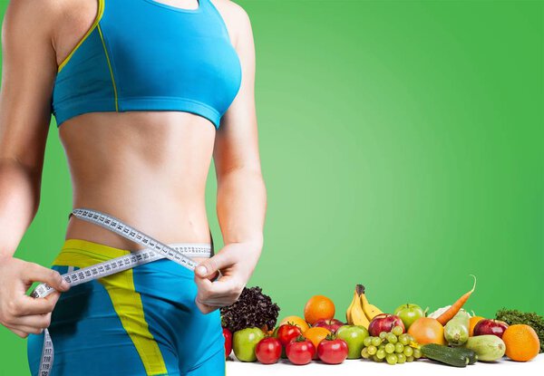 young woman measuring her thin waist 