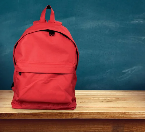 Mochila roja sobre mesa de madera —  Fotos de Stock