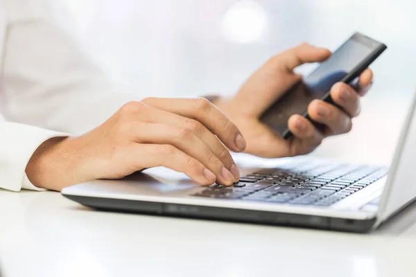 Mannelijke handen met telefoon op laptop — Stockfoto