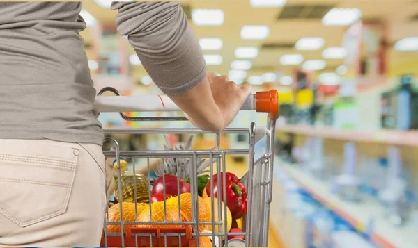 Woman pushing shopping cart — Stock Photo, Image
