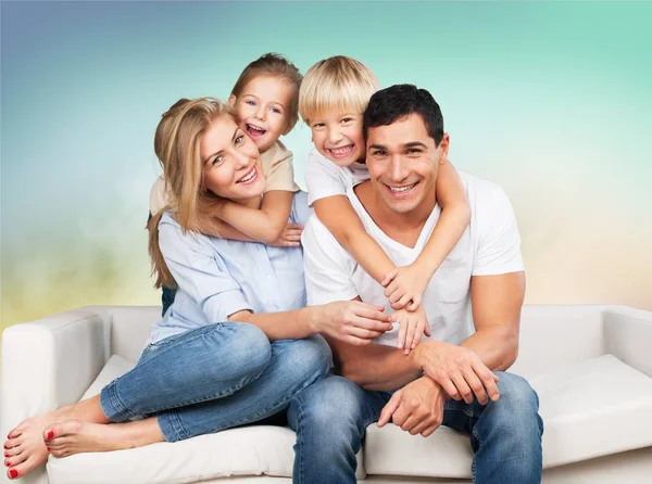 Familia sonriente sentada en el sofá —  Fotos de Stock