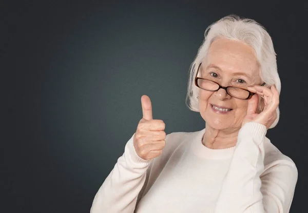奶奶笑着和显示标志大拇指 — 图库照片