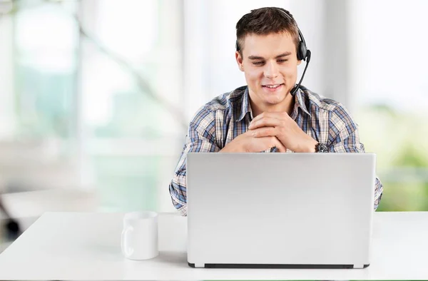 Χαρούμενος νεαρός άνδρας λειτουργεί σε φορητό υπολογιστή του — Φωτογραφία Αρχείου
