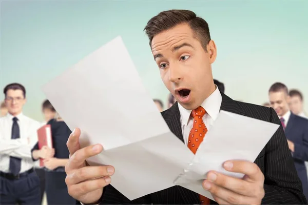 Shocked businessman looking at paper — Stock Photo, Image