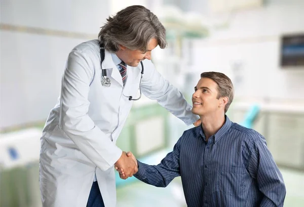 Médico sonriendo con paciente masculino — Foto de Stock