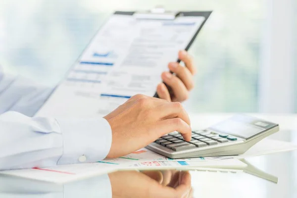 businessman's hand counting on calculator