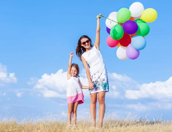 Mulher com menina e balões de ar — Fotografia de Stock