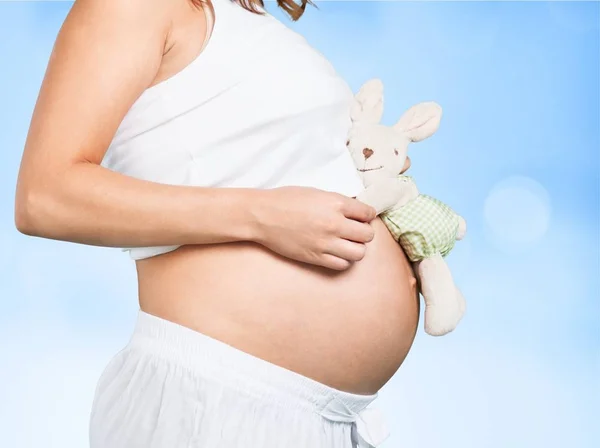Беременная женщина с игрушечным кроликом — стоковое фото