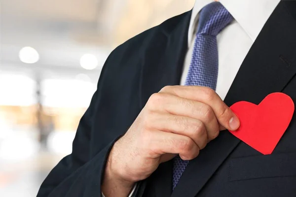 Hombre de traje sosteniendo papel corazón rojo — Foto de Stock