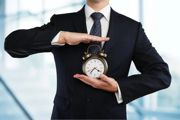 Business man holding clock — Stock Photo, Image