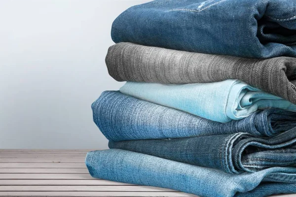 Stapel Jeans auf Holztisch — Stockfoto