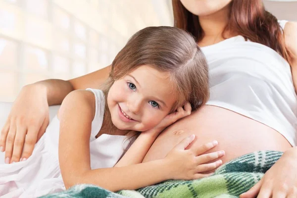 Mooie zwangere vrouw met haar dochter — Stockfoto