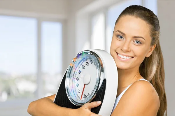 Mujer joven sosteniendo escamas — Foto de Stock