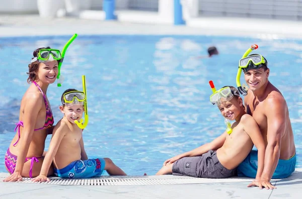 Glückliche Familie spielt im Schwimmbad. — Stockfoto