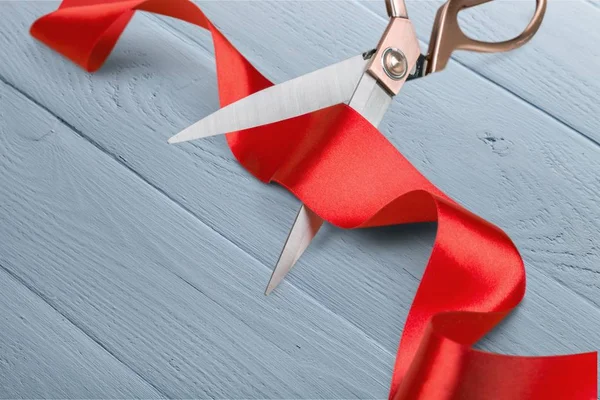 Scissors cutting red ribbon — Stock Photo, Image