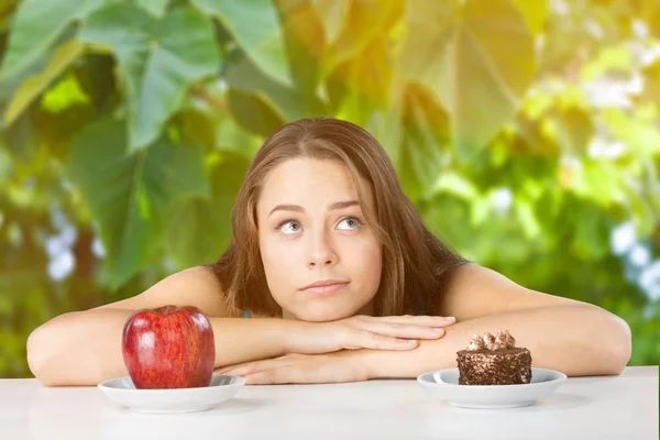 Kvinnan gör valet mellan apple och tårta — Stockfoto