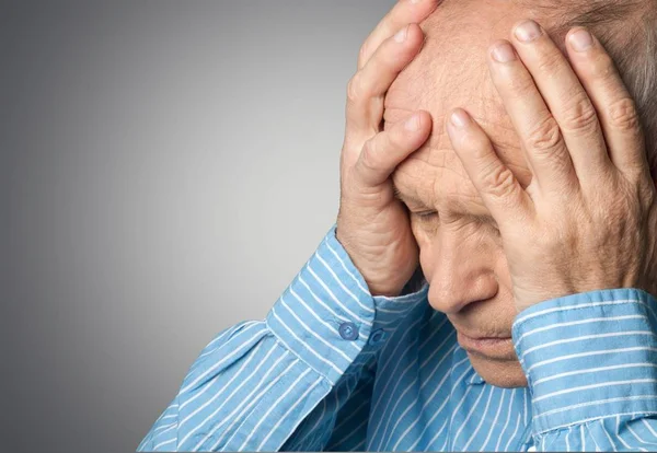 Älterer Mann hält seinen Kopf vor Schmerzen — Stockfoto