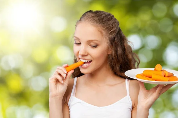 Mujer joven comiendo una zanahoria —  Fotos de Stock