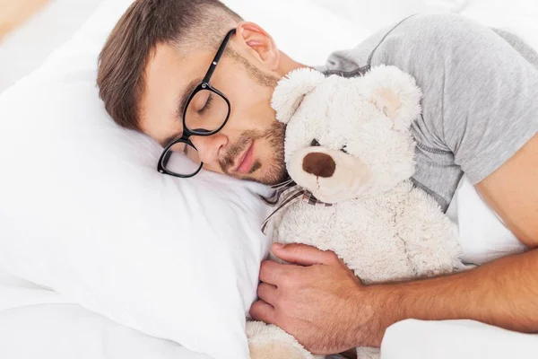 Adam yatakta uyuyor.