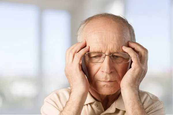 Älterer Mann hält seinen Kopf vor Schmerzen — Stockfoto