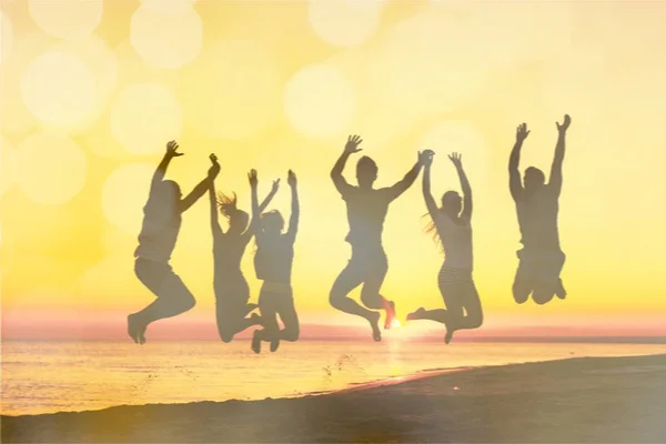 Friends jumping on beach — Stock Photo, Image